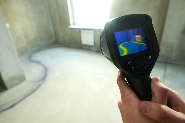 Thermal imaging camera inspection of construction building to check temperature and finding heating pipes in floor
